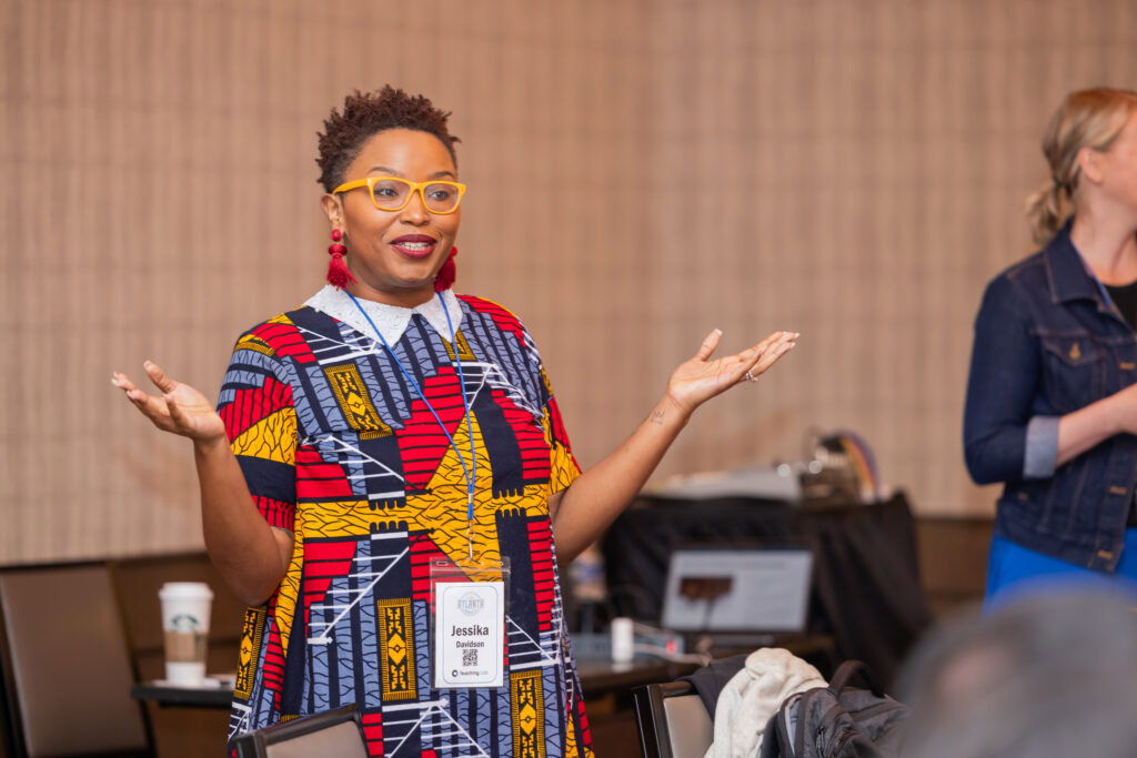 A woman at a conference standing an shrugging