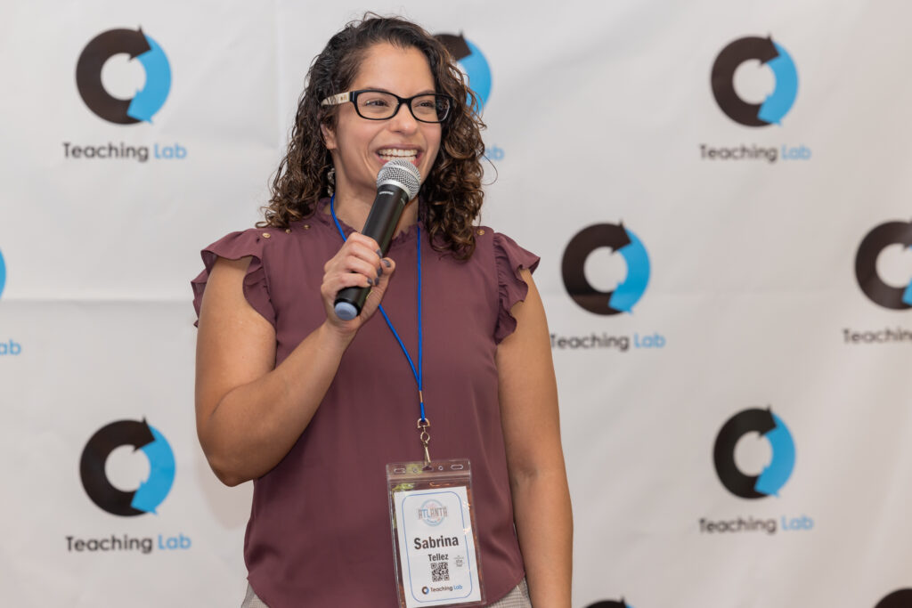 A woman at a conference holding a microphone and speaking