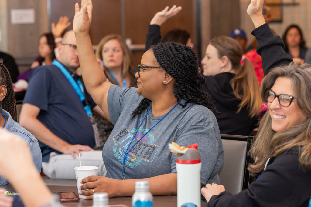 A teacher at a conference raising her hand
